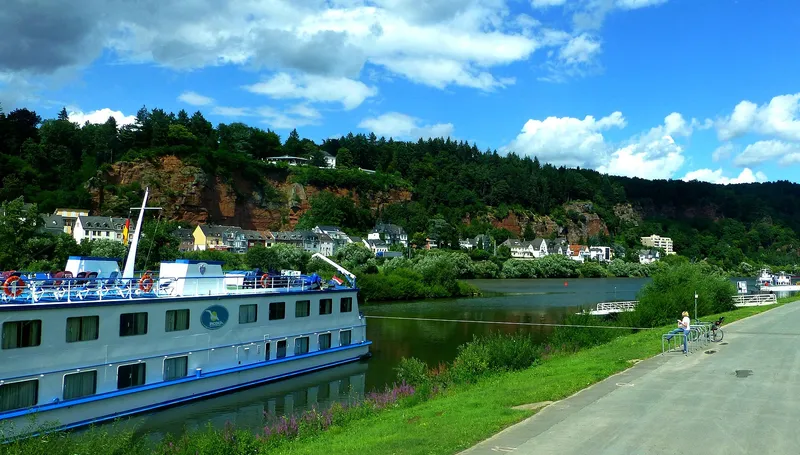 Ausflugsschiff auf der Mosel bei Trier mit Uferpromenade und Weinbergen