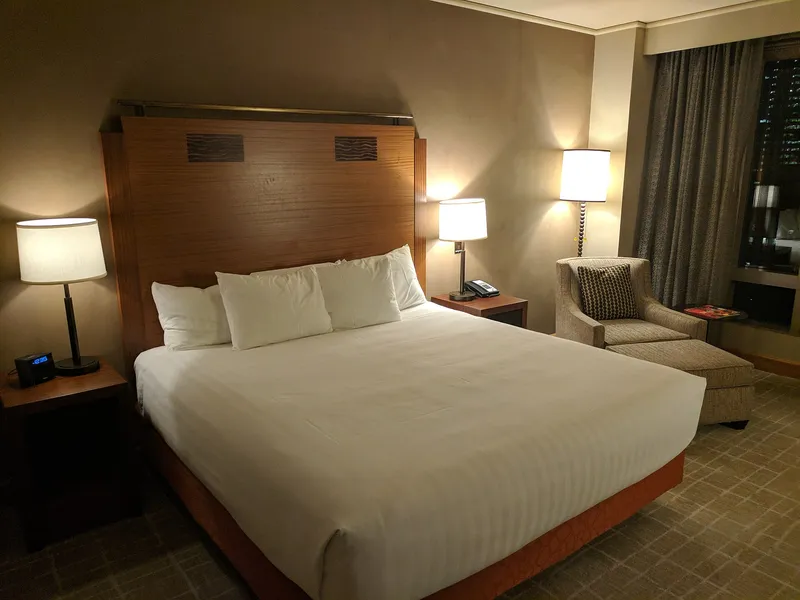 Aufgeräumtes Hotelzimmer mit gemachtem Doppelbett